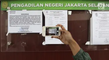 Pengunjung mengambil gambar pengumuman pembekuan Jamaah Ansharut Daulah (JAD) di salah satu papan pengumuman PN Jakarta Selatan, Senin (6/8). Jaksa melaksanakan eksekusi putusan pembekuan JAD sebagai organisasi terlarang. (Liputan6.com/Herman Zakharia)