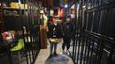 Anak muda membeli makanan di restoran berkonsep penjara "Sel 16" di Teheran, 4 Februari 2022. Sebagian hasil bisnis digunakan untuk membebaskan mereka yang mendekam di penjara karena utang yang belum dibayar dimana lebih dari 11.000 warga Iran dipenjara karena gagal membayar utang (ATTA KENARE/AFP)