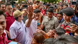 Wakil presiden terpilih, Gibran Rakabuming Raka (tengah) menyapa orang-orang di Jakarta pada 24 April 2024. (BAY ISMOYO/AFP)