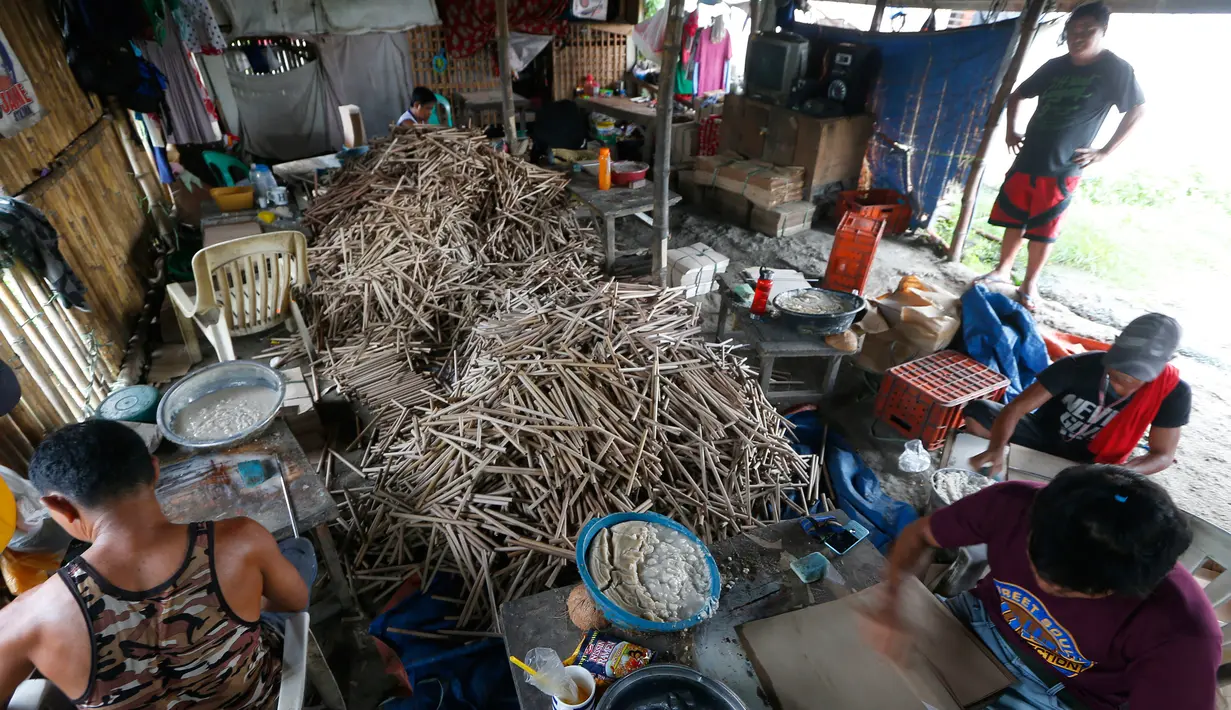 Pekerja menyelesaikan pembuatan kembang api di dalam sebuah gubuk di provinsi Bulacan, utara Manila, Rabu (27/12). Seperti banyak negara di Asia, warga Filipina juga akan merayakan malam pergantian tahun dengan kembang api tradisional. (AP/Bullit Marquez)