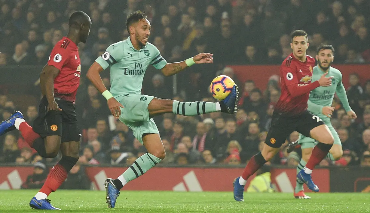 Striker Arsenal, Pierre-Emerick Aubameyang mengontrol bola dari kawalan bek Manchester United, Eric Bailly selama pertandingan lanjutan Liga Inggris di stadion Old Trafford (5/12). MU bermain imbang 2-2 atas Arsenal. (AFP Photo/Oli Scarff)