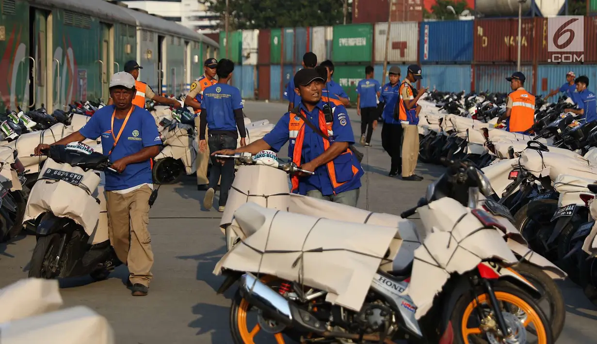 Petugas membawa sepeda motor untuk diangkut dengan kereta api Stasiun Kampung Bandan, Jakarta, Senin (11/6). Program mudik gratis ini digagas Kemenhub tersebut melayani pengiriman ke beberapa daerah di Pulau Jawa. (Liputan6.com/Immanuel Antonius)