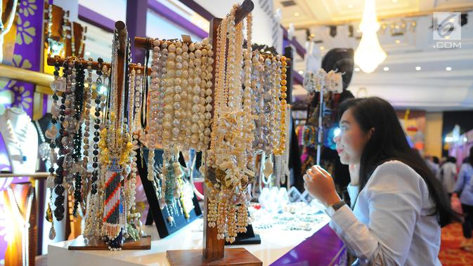 Pengunjung mencoba perhiasan hasil kerajinan tangan dalam pameran DhawaFest Pesona 2019 di Kementerian Keuangan, Jakarta, Rabu (8/5/2019). Acara pameran produk lokal nusantara tersebut diselenggarakan hingga 10 Mei 2019 mendatang. (Liputan6.com/Angga Yuniar)