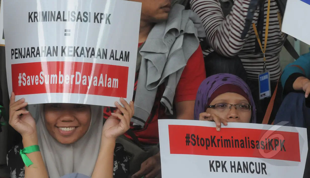 Aktivis menunjukkan poster berisi dukungan saat menggelar aksi di halaman gedung KPK, Jakarta, Jumat (13/3/2015). Mereka menolak kriminalisasi KPK yang selama ini konsisten melakukan upaya pemberantasan korupsi. (Liputan6.com/Herman Zakharia)
