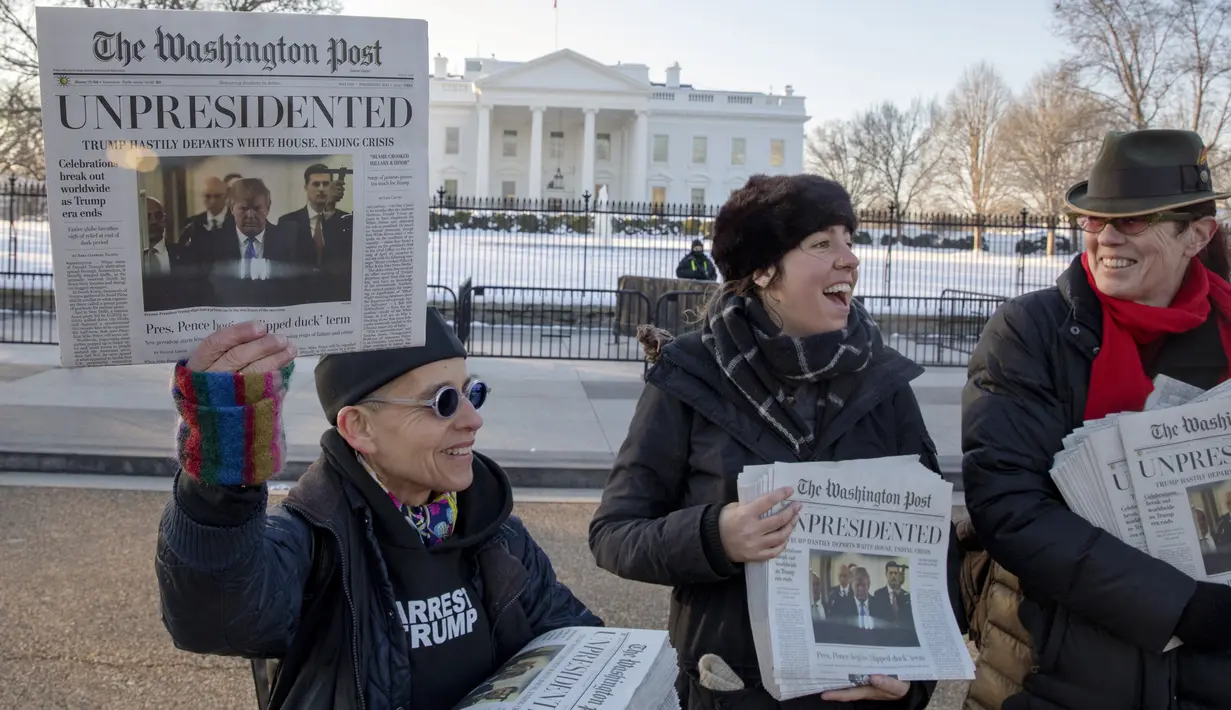 Aktivis membagikan surat kabar tiruan The Washington Post berisi Presiden Donald Trump mengundurkan diri di Washington, DC, Rabu (16/1). Surat kabar bertanggal 1 Mei 2019 itu mirip dengan salinan asli The Washington Post (Tasos Katopodis/Getty Images/AFP)