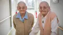Simone Thiot (kiri) dan Paulette Olivier berjalan saat berada di Ephad "Les Bois Blancs", Prancis (13/2). Paulette dan Simone perempuan berusia 104 tahun ini diyakini sebagai wanita kembar tertua di dunia. (AFP PHOTO/GUILLAUME souvent)