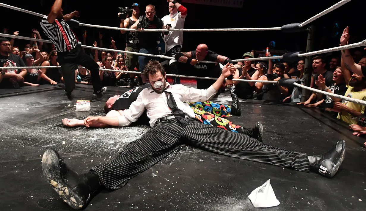 Pegulat terkapar didalam ring saat mengikuti pertandingan gulat Hoodslam di Oakland, California (7/7). Pertandingan ini menampilkan pegulat dengan karekater yang lebih aneh dari pertandingan gulat profesional pada umumnya. (AFP Photo/Josh Edelson)