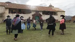 Pria dan wanita menari di alun-alun kota hantu Santa Barbara, Peru, Sabtu (4/12/2021). Pada masa penjajahan Spanyol, Santa Barbara pernah menjadi tambang merkuri terbesar di Amerika. (AP Photo/Franklin Briceño)