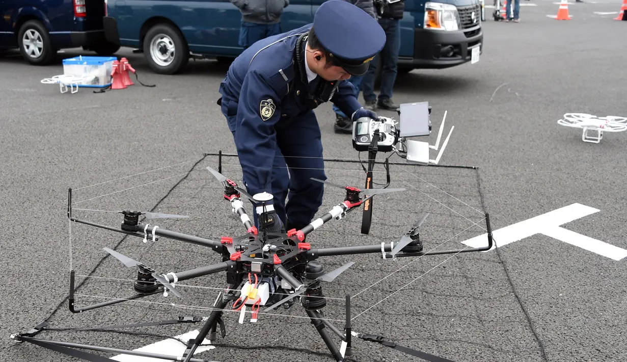 Seorang polisi menyiapkan drone yang dilengkapi jaring saat latihan penanggulangan anti terorisme di Tokyo, Jepang, Minggu (17/1). Latihan yang diikuti 400 petugas kepolisian dan keamanan ini untuk persiapan acara Tokyo maraton. (AFP/Toshifum Kitamura)