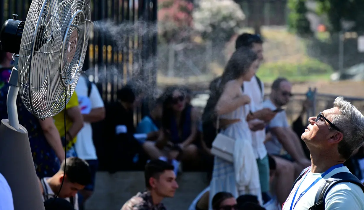 Sebuah kipas angin menyemprotkan air di sepanjang gerbang Colosseum, Roma untuk menyegarkan para turis pada tanggal 11 Juli 2024. (Tiziana FABI/AFP)