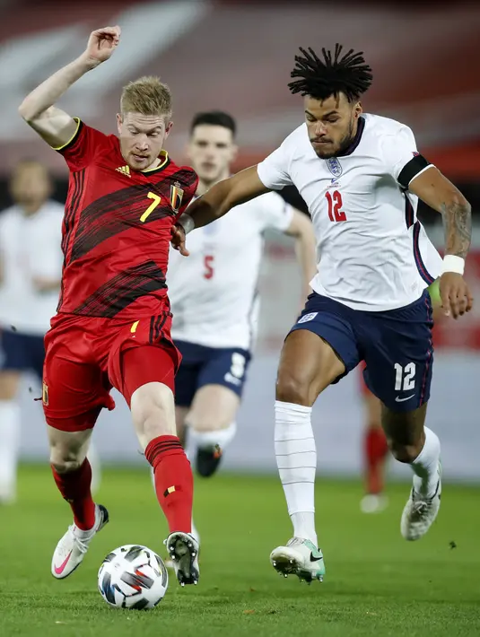 Gelandang Belgia, Kevin De Bruyne mengontrol bola dari kawalan bek Inggris, Tyrone Mings pada pertandingan UEFA Nations League di stadion King Power di Leuven, Belgia, Minggu (15/11/2020). Belgia menang atas Inggris 2-0. (AP Photo/Francisco Seco)