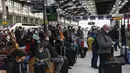 Orang-orang yang memakai masker menunggu dengan barang bawaan mereka di stasiun kereta Gare de Lyon di Paris, Jumat (19/3/2021). Prancis menerapkan karantina wilayah di Paris dan beberapa daerah lain di bagian utara selama sebulan dan dimulai pada Jumat tengah malam. (AP Photo/Michel Euler)