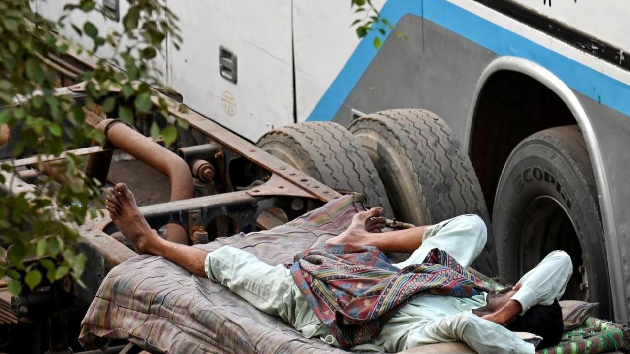 Dalam sebuah pemandangan yang menarik ini, para sopir bus di sebuah terminal di Lahore terlihat tidur nyenyak di atas ranjang di bawah pohon-pohon yang rindang. Foto: ARIF ALI / AFP<br>