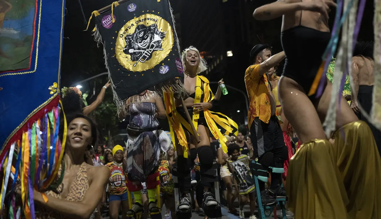 Peserta pesta jalanan yang dikenal sebagai blocos, menari selama protes terhadap pembatasan oleh pejabat kota di Rio de Janeiro, Brasil (13/4/2022). Balai Kota telah melarang pesta jalanan selama perayaan Karnaval, yang tertunda hampir dua bulan karena pandemi. (AP Photo/Silvia Izquierdo)