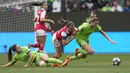 Pemain Arsenal, Katie McCabe (tengah) berebut bola dengan pemain Wolfsburg, Jule Brand (kanan) dan Lena Oberdorf pada laga leg pertama semifinal Liga Champions Wanita 2022/2023 di Volkswagen Arena, Wolfsburg, Jerman, Minggu (23/04/2023). Laga berakhir dengan skor 2-2. (AP Photo/Martin Meissner)