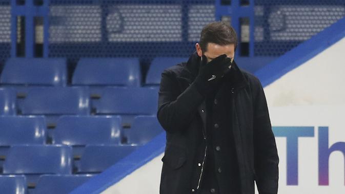 Pelatih Chelsea, Frank Lampard menutupi wajahnya selama pertandingan melawan Aston Villa pada lanjutan Liga Inggris di Stamford Bridge, London, Selasa (29/12/2020). Chelsea dipaksa bermain imbang atas Aston Villa 1-1. (Catherine Ivill/Pool via AP)