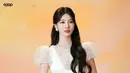 Rambut panjang bergelombangnya dibiarkan terurai lembut, dengan sebagian ditata ke atas untuk menciptakan volume yang pas.  [@skuukzky/@management_soop].
