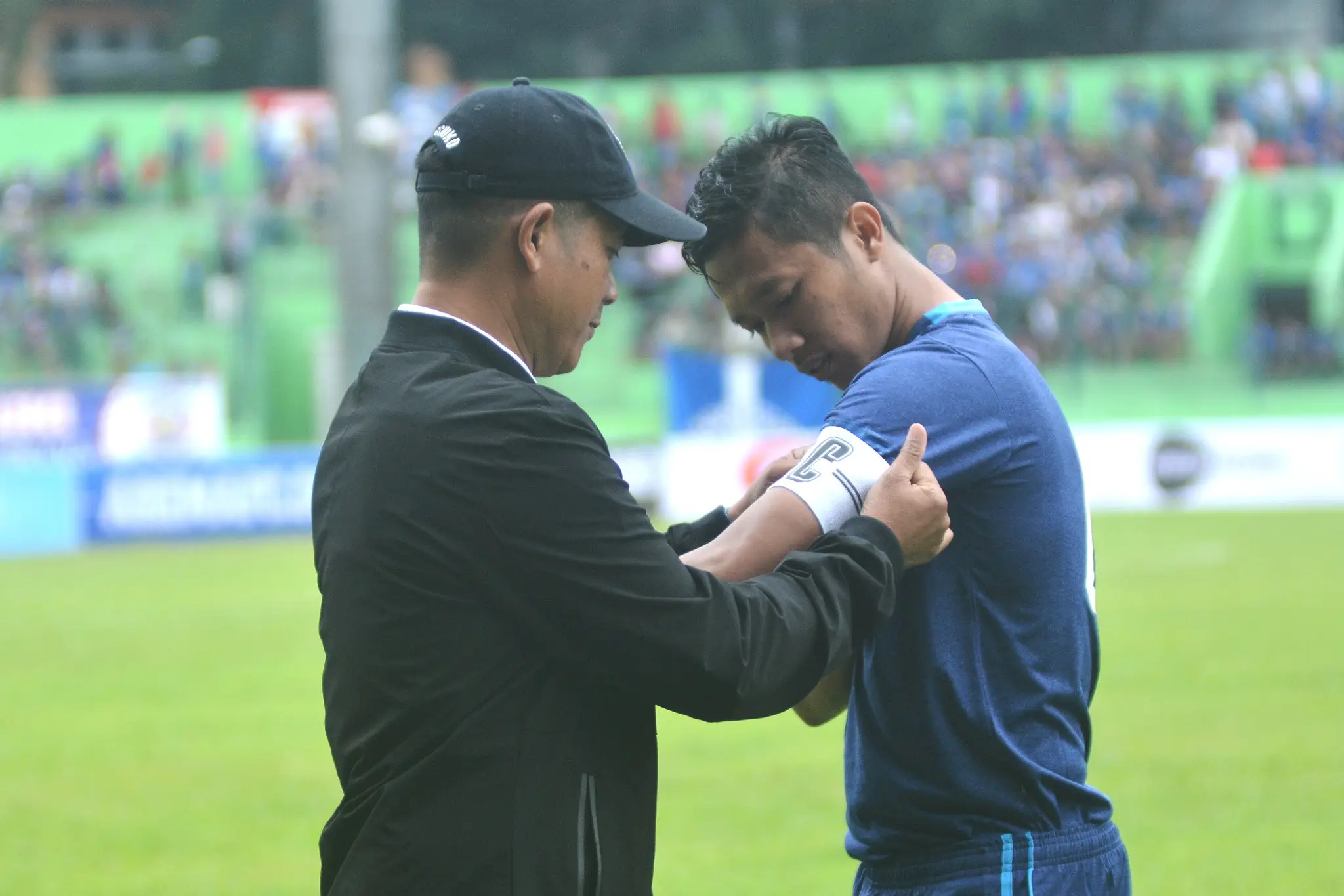 Pelatih Arema, Joko Susilo menyematkan ban kapten secara simbolis kepada Dendi Santoso. (Liputan6.com/Rana Adwa)