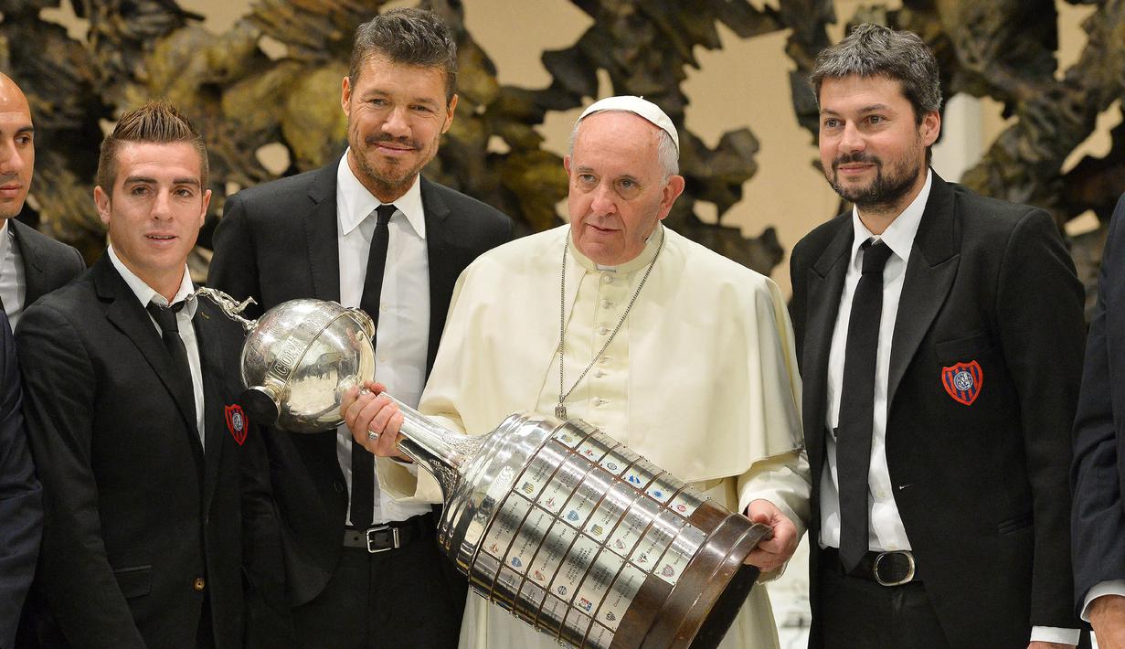 Paus Fransiskus memegang trofi Piala Libertadores bersama para pemain San Lorenzo pada 20 Augustus 2014 di Vatican. (AFP/Osservatore Romano)