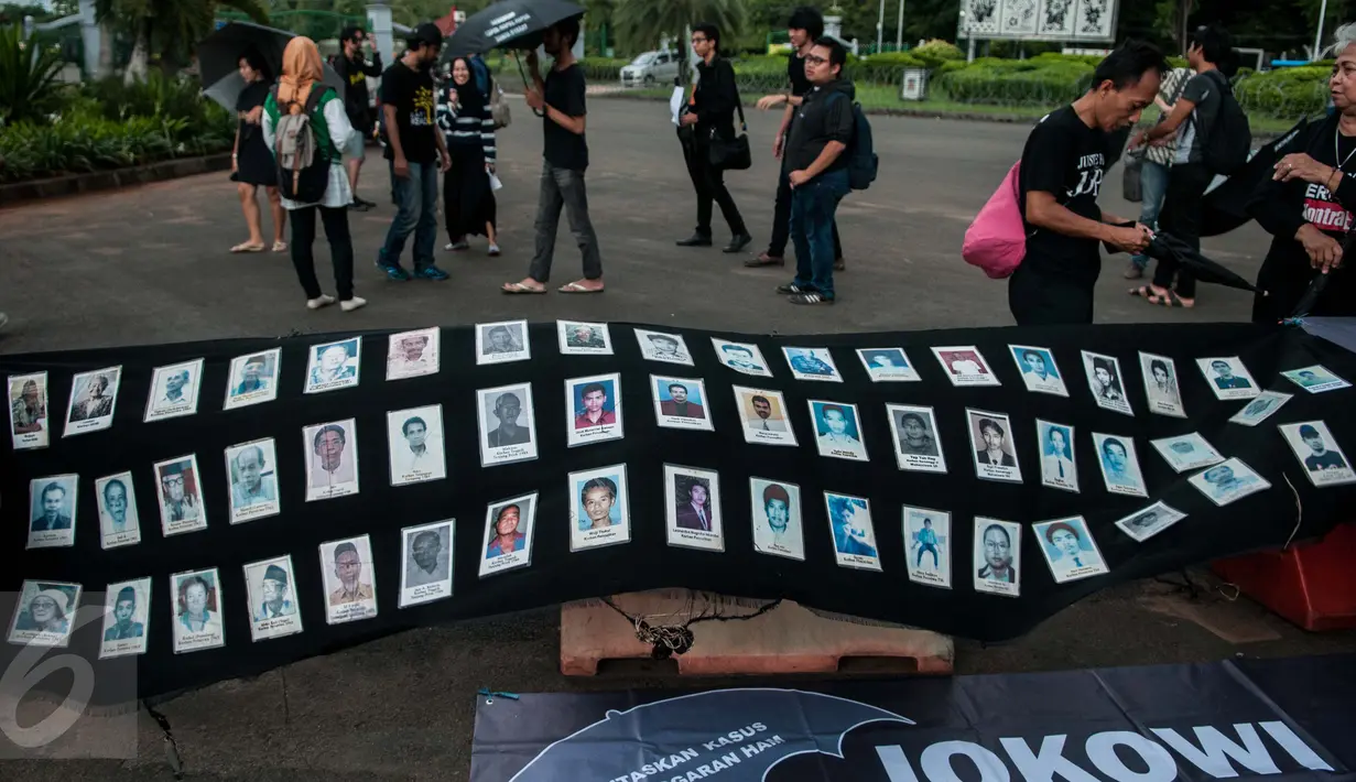 Sejumlah foto orang-orang yang hilang dipajang saat aksi Kamisan ke-482 di depan Istana Merdeka, Jakarta, Kamis (23/2). Mereka menuntut Presiden Jokowi untuk menuntaskan segala kasus pelanggaran HAM. (Liputan6.com/Gempur M Surya) 