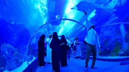Wisatawan mengunjungi akuarium Dubai Mall di pusat kota Dubai, UEA pada Rabu (2/1). Di sana ada 33.000 biota laut dengan 85 spesies berbeda, termasuk 400 kombinasi dari hiu dan ikan pari. (GIUSEPPE CACACE / AFP)