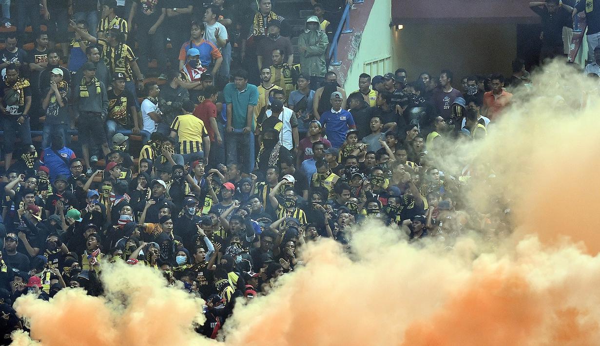 Para pendukung Malaysia yang kecewa dengan penampilan timnasnya menyalakan suar saat laga menghadapi Arab Saudi pada Kualifikasi Piala Dunia 2018 di Malaysia, Selasa (8/9/2015). (AFP/Manan Vatsyayana)