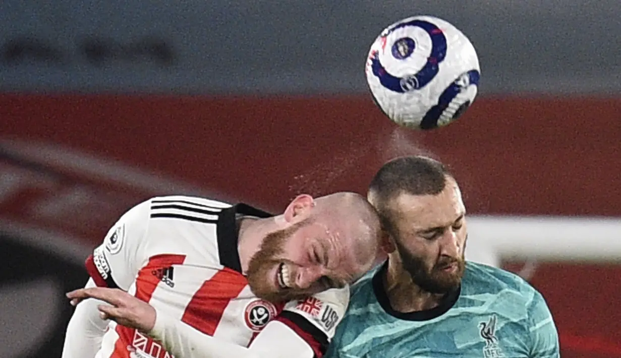 Penyerang Sheffield United, Oliver McBurnie berebut bola dengan bek Liverpool, Nathaniel Phillips pada pertandingan lanjutan Liga Inggris di stadion Bramall Lane di Sheffield, Inggris, Senin (1/3/2021). Kini Liverpool berada di posisi keenam klasemen Liga Inggris. (Oli Scarff, Pool via AP)