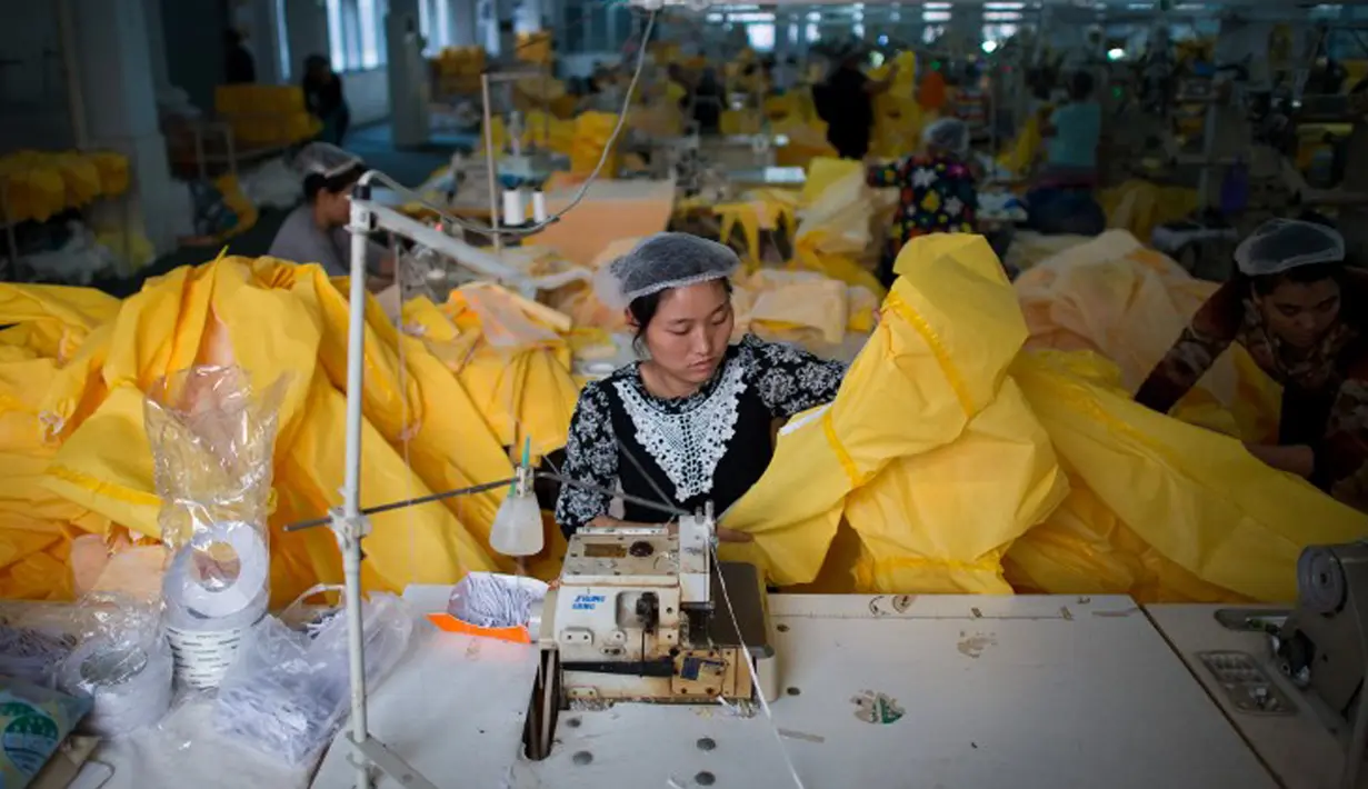 Pekerja menjahit pakaian pelindung khusus yang akan digunakan petugas kesehatan untuk merawat pasien virus Ebola di pabrik berbasis US Lakeland Industries di kota Anqiu di China, 23 Oktober 2014. (AFP Photo/JOHANNES EISELE)