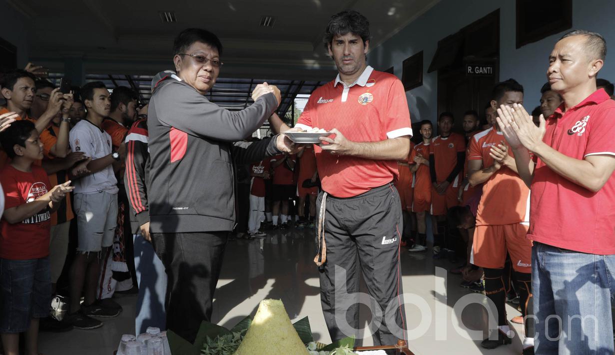 Dirut Persija Jakarta, Gede Widiade, memberikan nasi tumpeng kepada Pelatih Persija, Stefano Cugurra Teco. Macan Kemayoran menjadikan Lapangan Sutasoma sebagai tempat latihan tetap untuk mengarungi Liga 1. (Bola.com/M Iqbal Ichsan)