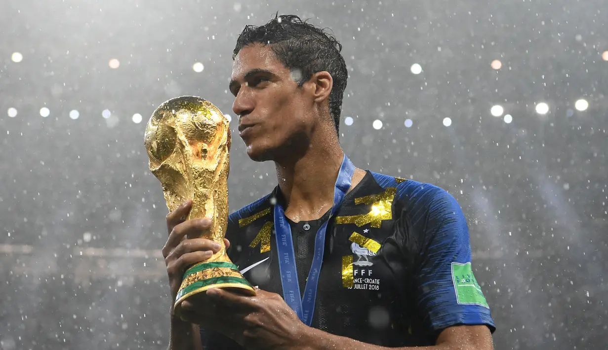 <p>Bek Prancis Raphael Varane memegang trofi Piala Dunia setelah memenangkan pertandingan final Piala Dunia Rusia 2018 melawan Kroasia di Stadion Luzhniki di Moskow pada 15 Juli 2018. Varane termasuk dalam skuat Prancis yang menjuarai Piala Dunia 2018 yang digelar di Rusia dan trofi UEFA Nations League pada 2022-21. (AFP/FRANCK FIFE)</p>