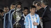 Lionel Messi tampak murung saat mendapatkan medali (JUAN MABROMATA / AFP)