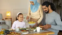 Sebuah keluarga muslim yang terdiri dari ayah, ibu, dan seorang anak sedang makan bersama (Foto Dok: Freepik/freepik).