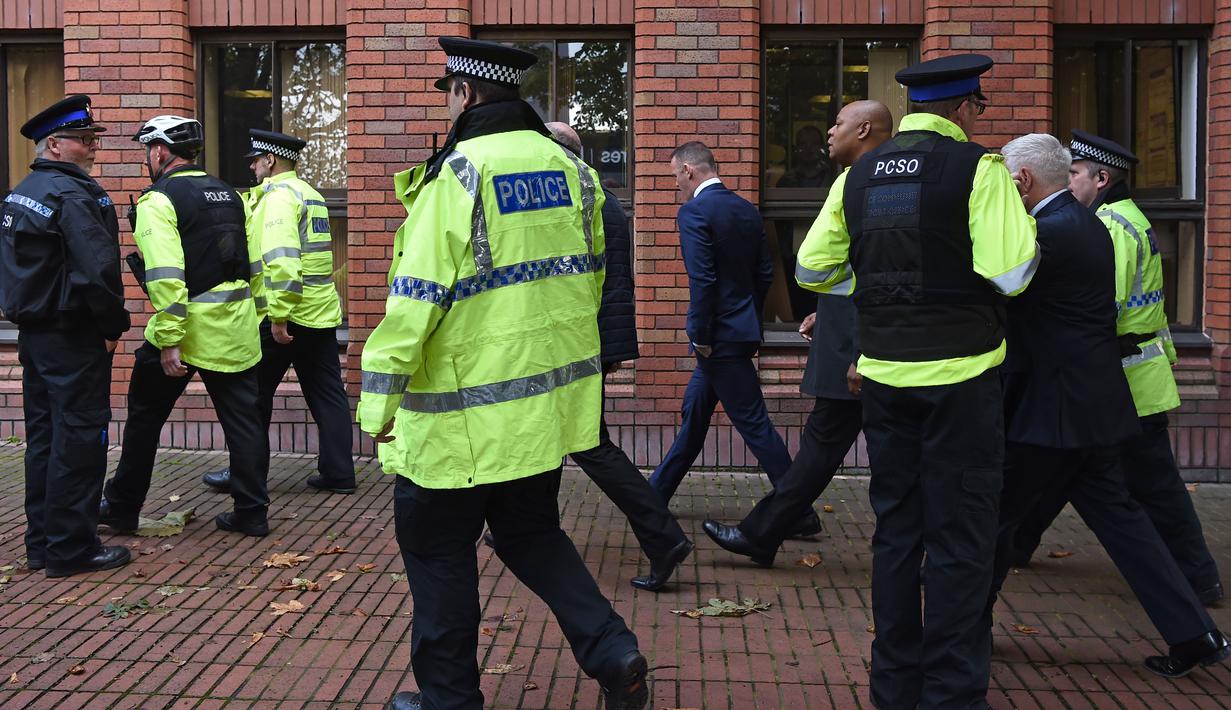 Pemain Everton, Wayne Rooney (tengah) dikawal Polisi saat memenuhi panggilan pengadilan Stockport Magistrates di Stockport, Inggris, (18/9/2017). Kehadiran Rooney di pengadilan karena kedapatan mengemudi saat mabuk. (AFP/ Paul Ellis)