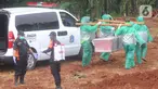 Petugas membawa jenazah korban COVID-19 yang akan dimakamkan di TPU Pondok Ranggon, Jakarta Timur, Rabu (1/4/2020). Hari ini di TPU Pondok Ranggon hingga menjelang sore hari tercatat sembilan belas jenazah dimakamkan baik yang berstatus ODP, PDP maupun postif COVID-19. (merdeka.com/Arie Basuki)