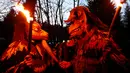 Peserta mengenakan kostum iblis membawa obor saat mengikuti parade tardisional Perchtenlauf di Osterseeon dekat Munchen, Jerman (17/12). Dalam sejarahnya, kata Perchten berarti topeng perempuan yang menyimbolkan dewi kuno. (Reuters/Michaela Rehle)