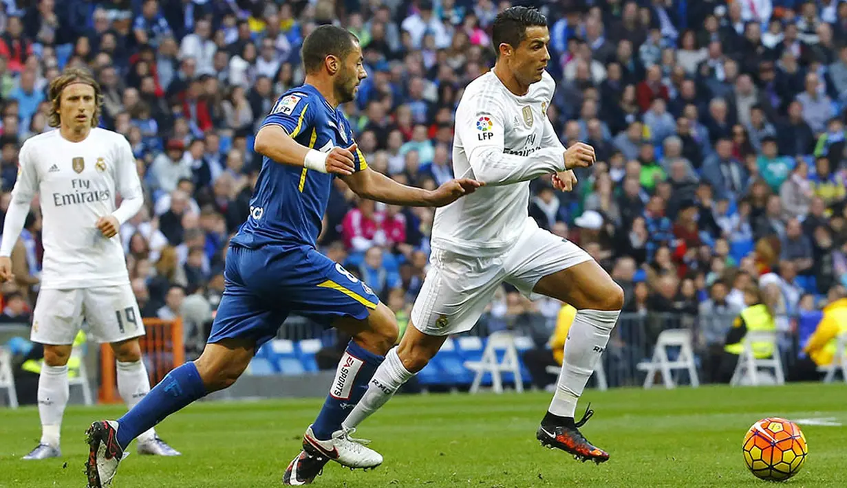 Bintang Real Madrid, Cristiano Ronaldo, melewati hadangan pemain Getafe, Mehdi Lacen, pada laga La Liga di Stadion Santiago Bernabeu, Spanyol, Sabtu (5/12/2015). (EPA/J.P.Gandul)