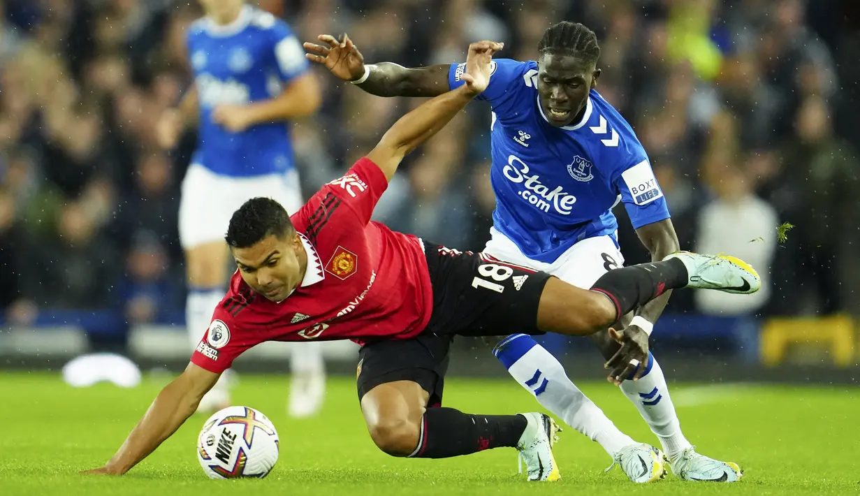 Gelandang Manchester United, Casemiro berebut bola dengan pemain Everton, Amadou Onana pada pertandingan lanjutan Liga Inggris di Goodison Park, di Liverpool, Inggris, Senin (10/10/2022). Sementara itu, Everton harus puas menelan kekalahan ketiganya dari delapan pertandingan. (AP Photo/Jon Super)