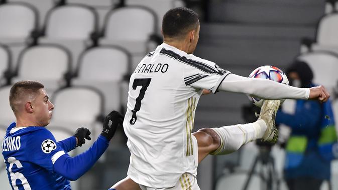 Bek Dynamo Kiev, Tudor Baluța berebut bola dengan penyerang Juventus, Cristiano Ronaldo melompat saat berebut bola pada matchday kelima Grup G Liga Champions di Allianz Stadium, Kamis (3/12/2020) dinihari WIB. Juventus meraih kemenangan 3-0 atas tamunya Dynamo Kyiv. (Marco Alpozzi/LaPresse via AP)
