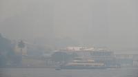 Sebuah kapal feri berlayar di pelabuhan saat kabut asap pekat menyelimuti Sydney, Australia, Selasa (10/12/2019). Kualitas udara di berbagai bagian kota dilaporkan tujuh kali di atas ambang berbahaya. (AP Photo/Rick Rycroft)