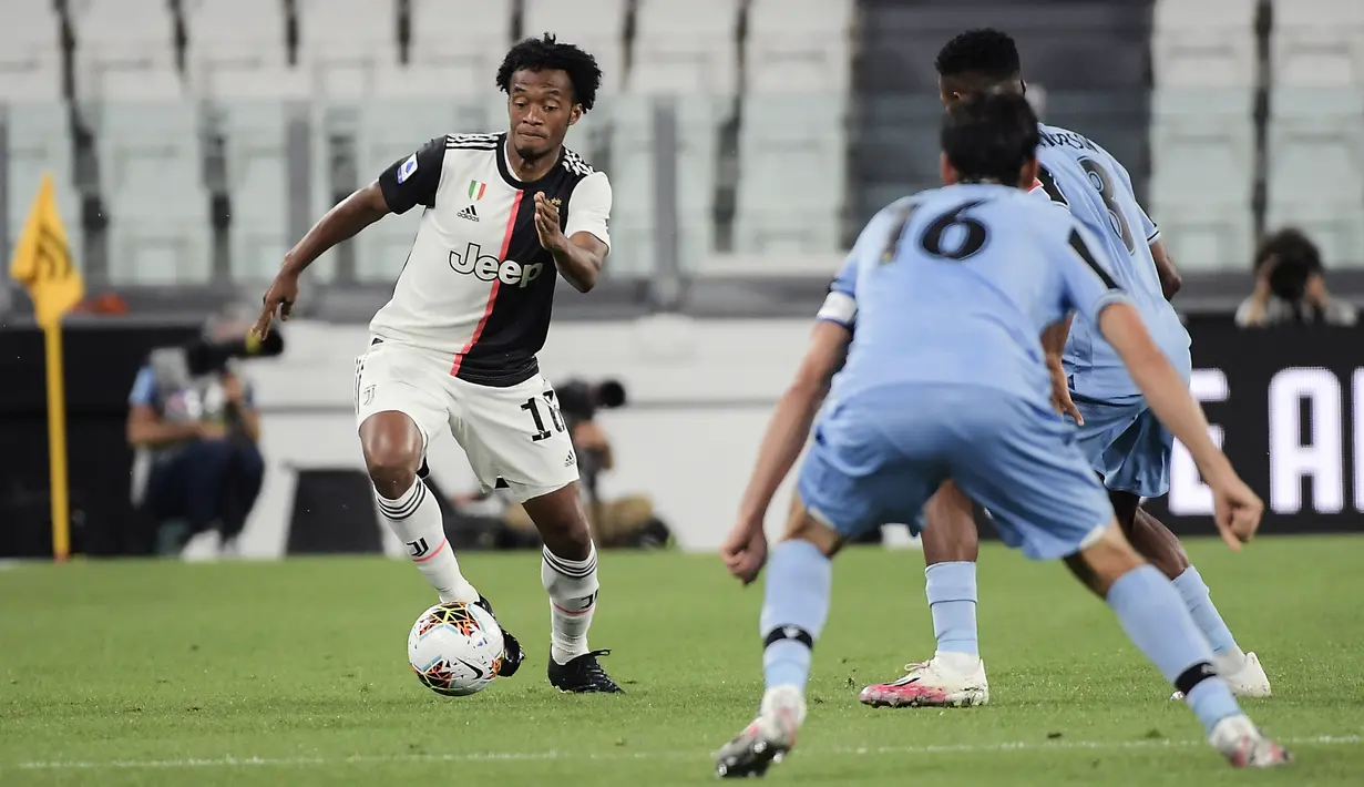 Pemain Juventus Juan Cuadrado (kiri) menggiring bola mencoba melewati pemain Lazio pada pertandingan Serie A di Allianz Stadium, Turin, Italia, Senin (20/7/2020). Dua gol Ronaldo membawa Juventus menang 2-1. (Marco Alpozzi/LaPresse via AP)