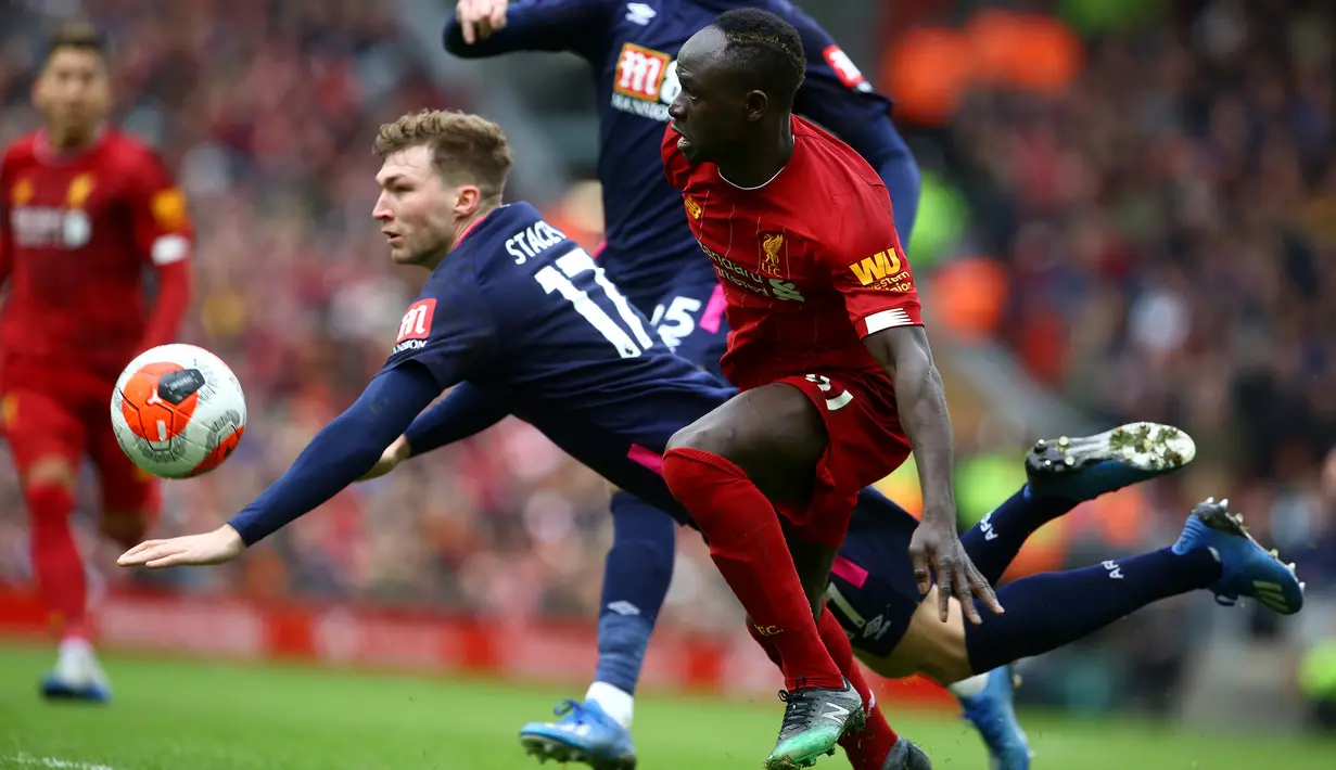 Striker Liverpool, Sadio Mane, berebut bola dengan pemain Bournemouth pada laga lanjutan Premier League 2019-2020 di Anfield, Liverpool, Sabtu (7/3) malam WIB. Liverpool menang 2-1 atas Bournemouth. (AFP/Geoff Caddick)