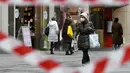 Seorang perempuan yang mengenakan masker berjalan-jalan dengan tas belanjannya di Wina, Austria pada Senin (8/2/2021). Austria mulai melonggarkan lockdown covid-19 ketiga mereka mulai 8 Februari dengan mengizinkan sekolah, museum dan toko dibuka kembali. (HELMUT FOHRINGER /APA/AFP)