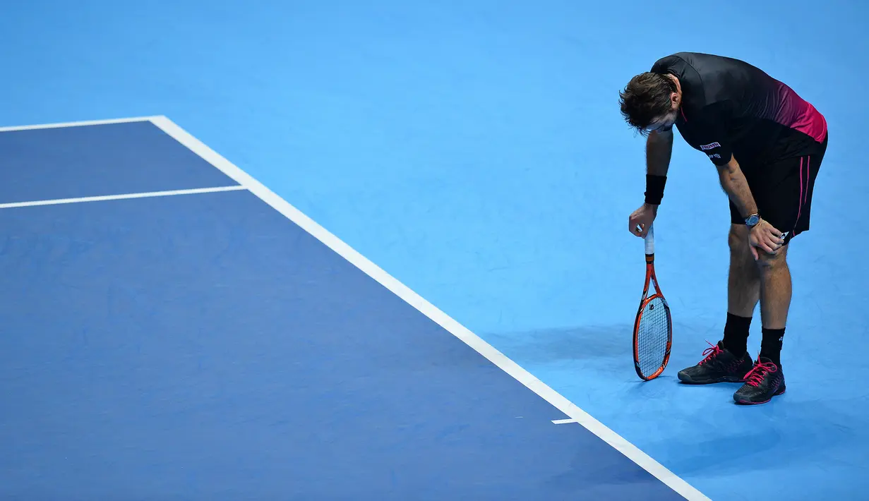 Petenis Swiss, Stanislas Wawrinka, bereaksi saat bertanding melawan petenis Spanyol, David Ferrer, dalam babak penyisihan grup ATP World Tour Finals di London, Inggris, (18/11/2015). (AFP Photo/Glyn Kirk)