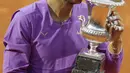 Petenis Spanyol, Rafael Nadal menggigit trofi juara turnamen tenis Italia Terbuka 2021 setelah mengalahkan petenis Serbia, Novak Djokovic di Foro Italico, Roma, Minggu (16/5/2021). Rafael Nadal menang dalam pertarungan tiga set 7-5, 1-6, dan 6-3 selama dua jam 49 menit. (AP Photo/Gregorio Borgia)