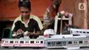 Iskandar (52) saat menyelesaikan pembuatan miniatur kereta api di kawasan Manggarai, Jakarta, Kamis (21/11/2019). Sudah 6 tahun bapak dari 2 anak ini menekuni profesi sebagai pembuat miniatur kereta api berbagai jenis, mulai dari KRL, kereta jarak jauh, hingga MRT. (merdeka.com/Iqbal S. Nugroho)