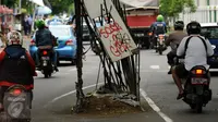 Pengendara melintas di sisi besi sisa pembangunan tiang Monorel di samping Stasiun Palmerah Jakarta, Selasa (15/12/2015). Sisa besi pembangunan tiang Monorel ini tampak tak terurus dan membahayakan pengguna jalan. (Liputan6.com/Helmi Fithriansyah)