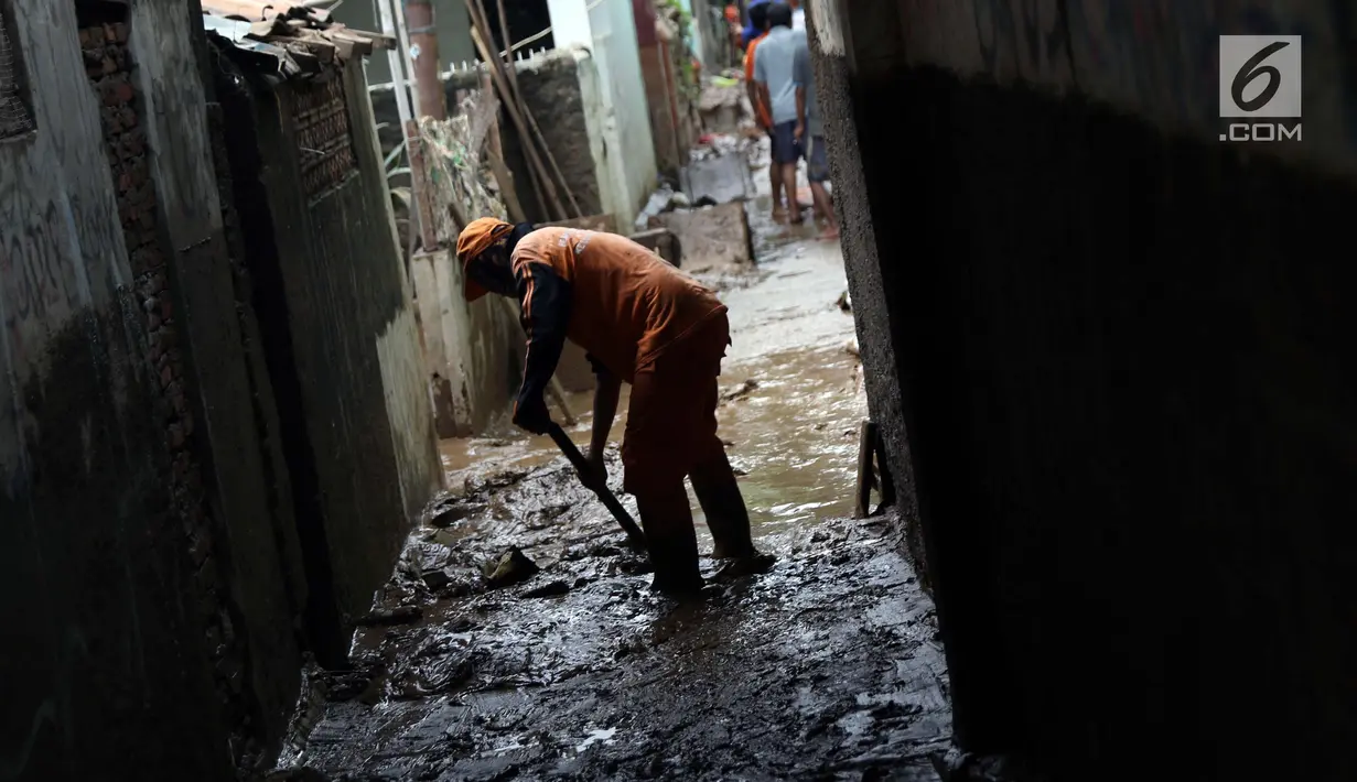 Petugas PPSU bersama warga membersihkan lumpur sisa banjir yang melanda kawasan Rawajati, Jakarta, Sabtu (27/4). Banjir akibat luapan air sungai Ciliwung sempat melanda kawasan ini pada Jumat (26/4). (Liputan6.com/Helmi Fithriansyah)