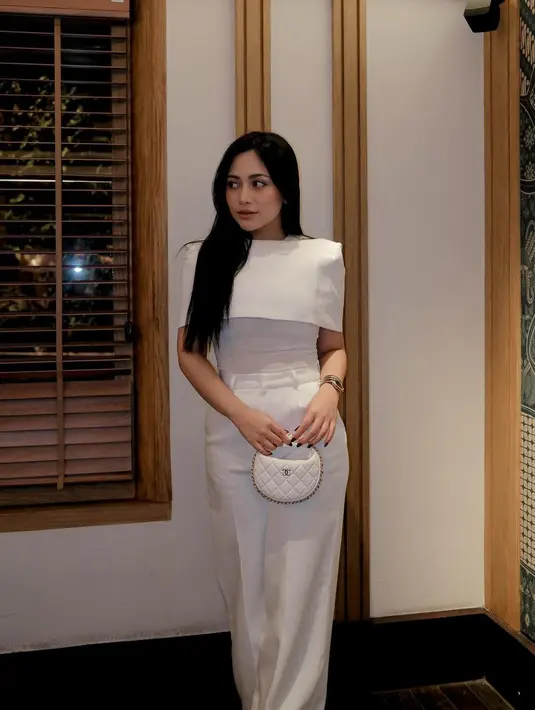 Penampilan elegan Rachel Vennya dibalut outfit serba putih. Ia mengenakan atasan putih dengan detail cape, dan celana panjangnya yang juga berwarna putih, kembali menenteng tas mini putih. [Foto: Instagram/rachelvennya]