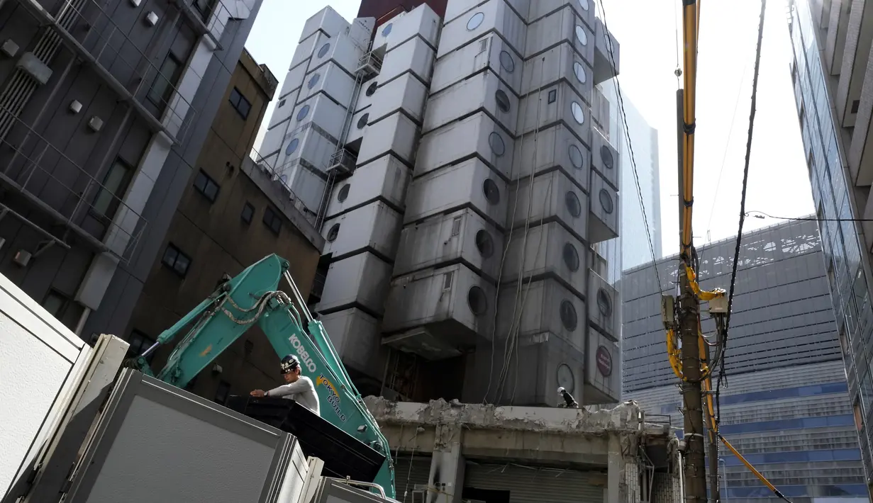 Tim pembongkaran mulai merobohkan Menara Kapsul Nakagin, bangunan ikonik yang dirancang arsitek Jepang Kisho Kurokawa pada tahun 1972, di distrik Ginza Tokyo, Selasa (12/4/2022). Pekerjaan pembongkaran menara yang terdiri dari 140 unit kapsul tersebut dimulai Selasa. (AP Photo/Eugene Hoshiko)