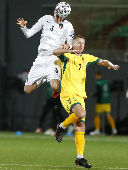Pemain Italia Alessandro Bastoni (kiri) memperebutkan bola udara dengan pemain Lithuania Martynas Dapkus pada pertandingan Grup C kualifikasi Piala Dunia 2022 di Stadion LFF, Vilnius, Lithuania, Rabu (31/3/2021). Italia menang 2-0. (AP Photo/Mindaugas Kulbis)